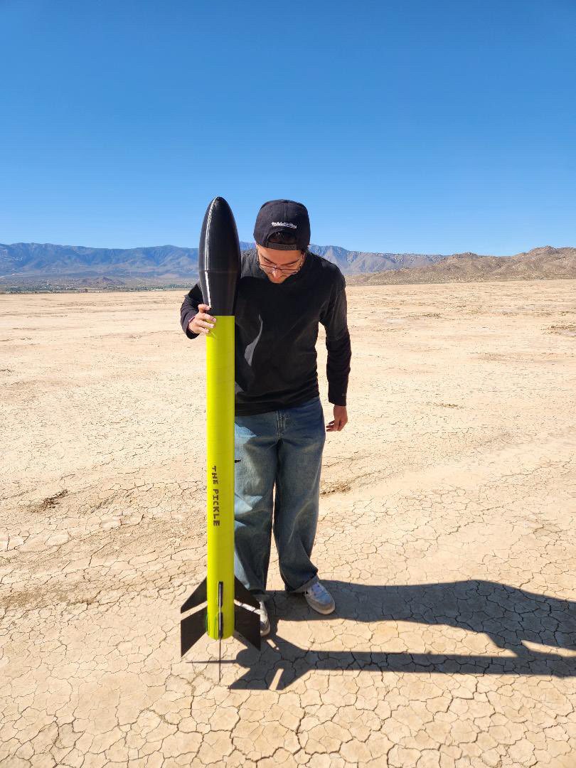 Domenico standing with a high-power rocket in the desert